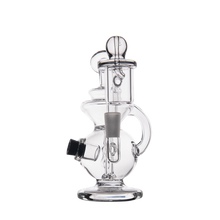 The MJ Arsenal Mini Jig Mini Dab Rig, featuring clear glass, multiple chambers, a cylindrical neck, side handle, and angled mouthpiece, is shown against a plain white background.