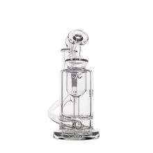The MJ Arsenal Ursa Mini Dab Rig features clear borosilicate glass, a cylindrical chamber, curved mouthpiece, and internal percolator—ideal for smooth sessions and shown upright on a white background.