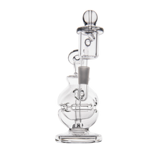 The MJ Arsenal Royale Mini Dab Rig is a clear borosilicate glass piece with a round base, upright chamber, attached banger, and fab egg percolator. Intricate glasswork stands out against the plain white background in the photo.