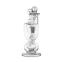 The MJ Arsenal Titan Mini Dab Rig is a clear borosilicate glass piece with multiple chambers, intricate internal percolators, a straight vertical mouthpiece, and a round base, photographed on a plain white background.