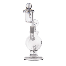 The MJ Arsenal Atlas Mini Dab Rig is a clear borosilicate glass water pipe with a rounded base, vertical chamber, cylindrical mouthpiece, bowl attachment, and intricate glasswork, displayed on a plain white background.