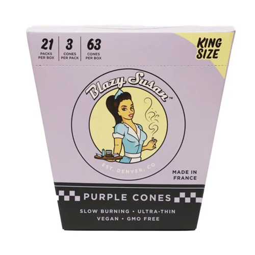 A box of Blazy Susan Purple Paper Cones, King Size, includes 21 packs (3 cones each) in purple packaging with a cartoon woman—totaling 63 ultra-thin, slow-burning, vegan, and GMO-free pre-rolled cones.
