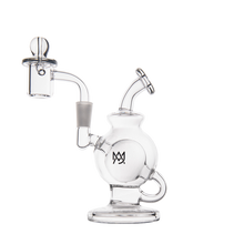 The MJ Arsenal Atlas Mini Dab Rig is a compact borosilicate glass piece with a spherical chamber, angled mouthpiece, loop handle, removable glass banger, flat base, and features a black geometric logo on its main chamber.