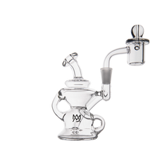 The MJ Arsenal Hydra Mini Dab Rig is a clear glass rig with a curved mouthpiece, handle, round base, attached quartz banger, and an MJ logo on the base. Set against a white background.