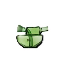 The MJ Arsenal Commander Blunt Bubbler is a modern green borosilicate glass vessel with two angled spouts, a wide rounded base, and a small artistic mark on the front. Its sculptural design evokes an abstract blunt bubbler style.