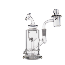 The MJ Arsenal Ursa Mini Dab Rig is made of clear borosilicate glass with a cylindrical base, bent neck, side arm to a quartz banger, logo on the chamber, and includes a glass carb cap—all shown on a white background.
