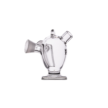 The MJ Arsenal Dubbler Original Double Bubbler, made of clear borosilicate glass with a rounded body, short angled spout, upright neck, and circular base, is shown photographed against a plain white background.