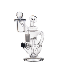 The MJ Arsenal Mini Jig Mini Dab Rig is a clear glass piece with multiple chambers, curved arms, a dome-shaped top, built-in storage jar, and recycler design, displayed on a plain white background.