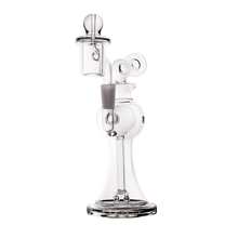 The MJ Arsenal Apollo Mini Dab Rig is a clear borosilicate glass piece with an intricate design, wide base, cylindrical neck, accented mouthpiece, and attached chamber and bowl—crafted for optimal flavor preservation.