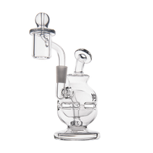 The MJ Arsenal Royale Mini Dab Rig, made from clear borosilicate glass with a rounded base, angled neck, and an attached quartz banger with carb cap, is shown against a plain white background.