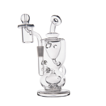 The MJ Arsenal Titan Mini Dab Rig is a clear borosilicate glass piece with intricate chambers, a bowl-shaped attachment, round base, and curved mouthpiece, shown against a white background.