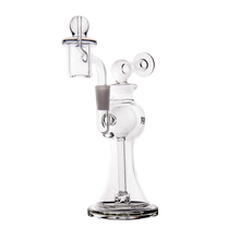 The MJ Arsenal Apollo Mini Dab Rig is a clear borosilicate glass piece with a wide base, curved neck, round accents, glass bowl, and percolator for flavor preservation, shown against a plain white background.