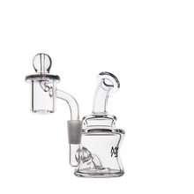 The MJ Arsenal Jammer Mini Dab Rig is a clear borosilicate glass rig with a rounded base, curved neck, and a glass carb cap. Its compact design features smooth lines and modern simplicity, shown here against a plain white background.
