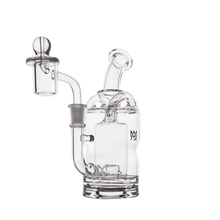 The MJ Arsenal Turbine Mini Dab Rig, made from clear borosilicate glass, features a curved neck, side-mounted downstem, and domed attachment. It is displayed against a white background.