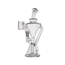 The MJ Arsenal Time Turner Mini Dab Rig is crafted from clear borosilicate glass with an hourglass body, angled arms, a cylindrical mouthpiece, and a side banger attachment for a sleek, fully transparent look.