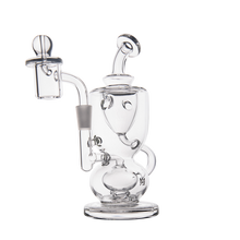 The MJ Arsenal Titan Mini Dab Rig is a clear borosilicate glass rig featuring multiple chambers, a bent neck, side percolator, and round base for concentrates. This transparent incycler dab rig is photographed on a plain white background.