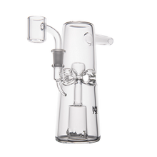 The MJ Arsenal Turret Mini Dab Rig features clear borosilicate glass, a wide base, side mouthpiece, bow-shaped center accent, and an attached quartz banger for portable style and function.