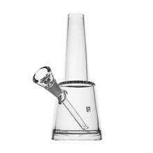 The MJ Arsenal Summit Bong is a clear borosilicate glass piece with a straight cylindrical neck and conical base, a downward-angled bowl, and a small black logo on the body, shown against a plain white background.