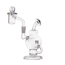 The MJ Arsenal Atlas Mini Dab Rig is a compact clear borosilicate glass piece with a round chamber, angled mouthpiece, banger attachment, and black logo on the body, displayed against a white background.