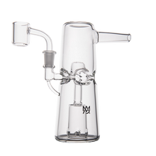 The MJ Arsenal Turret Mini Dab Rig features clear borosilicate glass, a cylindrical base, side mouthpiece, elevated left bowl, detailed central glasswork, and a small logo on the base—ideal for portable dabbing enthusiasts.