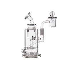 The MJ Arsenal Ursa Mini Dab Rig is a clear borosilicate glass rig with a cylindrical chamber, angled mouthpiece, side-mounted arm, and dome-shaped attachment, shown on a white background.