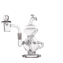 The MJ Arsenal Mini Jig Mini Dab Rig is a clear glass rig with intricate curved tubing, a small base, left-side banger, right handle, and recycler design, shown against a plain white background.