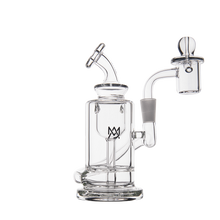 The MJ Arsenal Ursa Mini Dab Rig, made from clear borosilicate glass, has a cylindrical base, angled mouthpiece, attached banger, domed carb cap, and MV logo on the main chamber. Shown on a plain white background.