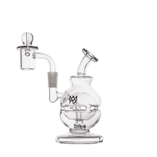The MJ Arsenal Royale Mini Dab Rig is a clear borosilicate glass water pipe with a spherical base, angled mouthpiece, side chamber, and overlapping M logo. It features a fab egg percolator for smooth hits.