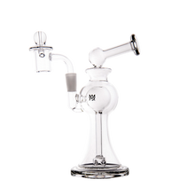 The MJ Arsenal Apollo Mini Dab Rig, made of clear borosilicate glass, features a wide base, angled mouthpiece, and side chamber for filtration. It stands upright on a plain white background and is designed for excellent flavor preservation.