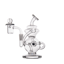 The MJ Arsenal Mini Jig Mini Dab Rig, made of clear glass with a curved neck, round chamber, side handle, and attached bowl piece, is displayed against a plain white background.