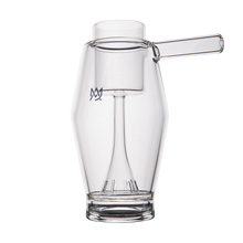 The MJ Arsenal Proxy Bubbler is a clear, uniquely-shaped borosilicate glass cup with a cylindrical handle, an inner glass structure, and a stylized M logo on the side, set against a plain white background.