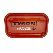 Tyson 2.0 Rolling Trays: Red rectangular trays featuring TYSON in bold black, UNDISPUTED CANNABIS in white, a small leaf graphic, and “2.0” handwritten on the right—designed for legal use and available in multiple sizes.