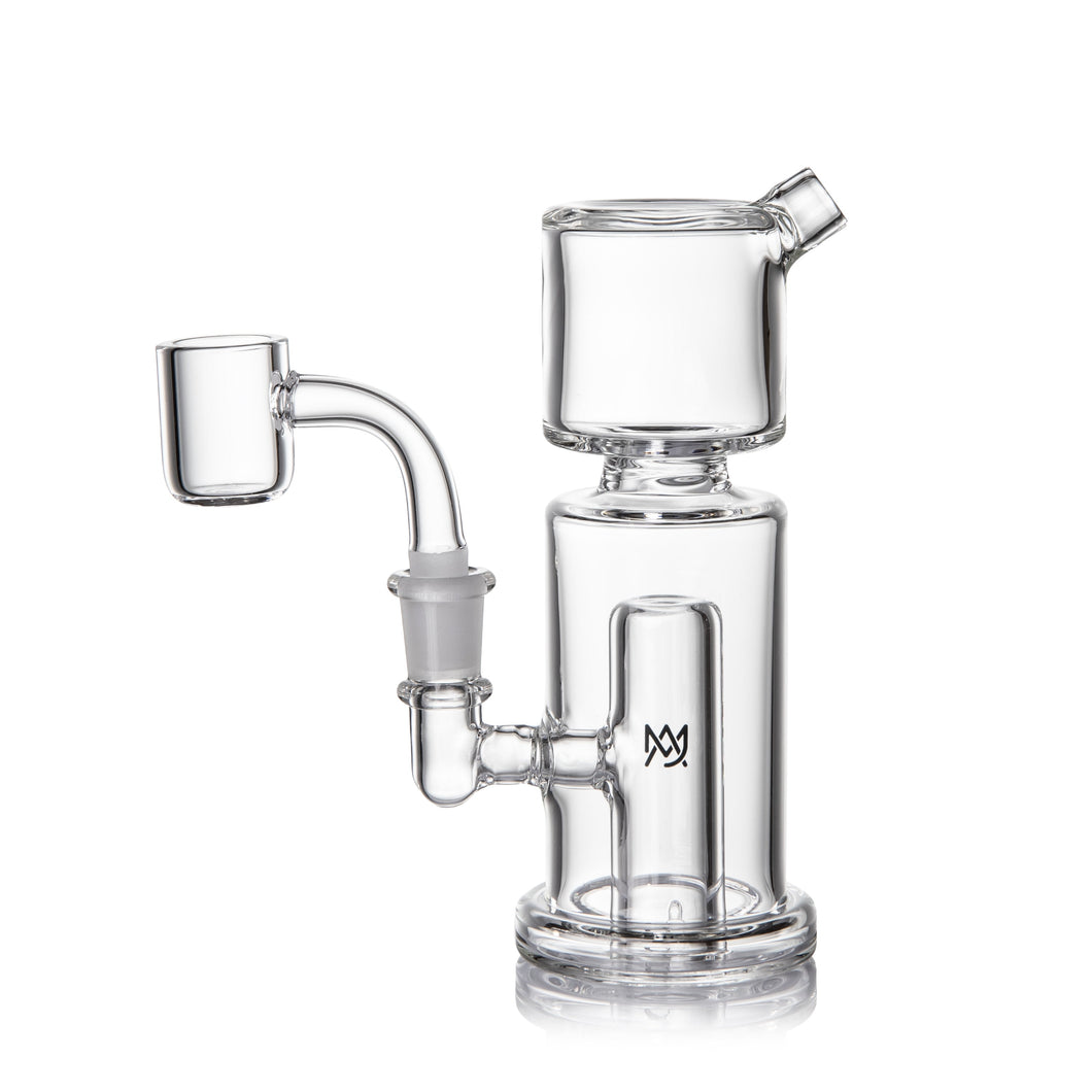 The MJ Arsenal Column Mini Dab Rig, made of clear borosilicate glass, showcases a cylindrical chamber, side percolator, bent neck, and 10mm quartz banger attachment on a white background.