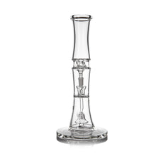 The MJ Arsenal Spire Glass Water Pipe, made from clear borosilicate glass with a wide round base, cylindrical neck, intricate internal glasswork, and a 14mm flower bowl, stands upright against a white background.