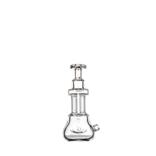 The MJ Arsenal Tetra is a clear borosilicate glass hand pipe featuring a flared base, cylindrical neck, and multiple chambers, showcased against a plain white background.