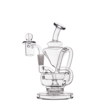 The MJ Arsenal Claude Mini Dab Rig is a clear glass mini rig with a bent neck, wide base, and attached bowl for concentrates, shown against a plain white background.