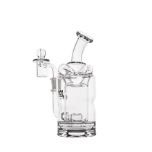 The MJ Arsenal Turbine Mini Dab Rig is a clear borosilicate glass water pipe with a cylindrical base, curved neck, and side chamber with a removable bowl, shown against a plain white background.