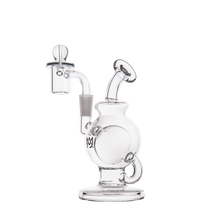 The MJ Arsenal Atlas Mini Dab Rig, made from clear borosilicate glass, has a round chamber, angled mouthpiece, side handle, and an attached banger with marble carb cap—shown on a plain white background.