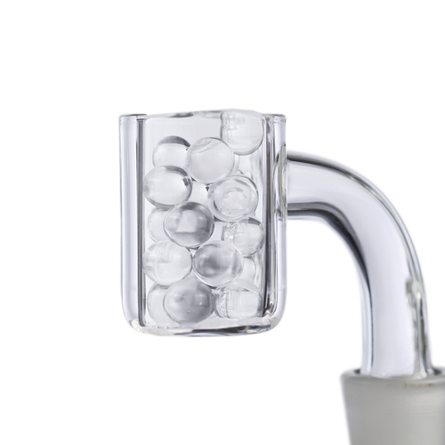 A close-up of a clear glass container with a curved handle displays MJ Arsenal Quartz Terp Pearls (6mm) against a white, minimalistic background—an ideal showcase for your dabbing accessories.