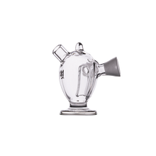 The MJ Arsenal Dubbler Original Double Bubbler is a clear, uniquely shaped borosilicate glass piece with a right-side spout, small angled top opening, and wide base, resembling a blunt bubbler. Displayed against a plain white background.
