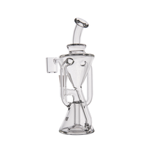 The MJ Arsenal Time Turner Mini Dab Rig is a clear borosilicate glass rig with a unique geometric design, curved and angled tubes, flared base, and side bowl attachment, shown on a white background.