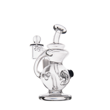 The MJ Arsenal Mini Jig Mini Dab Rig is a clear glass rig featuring a rounded base, curved neck, attached bowl, and built-in storage jar, shown on a plain white background.