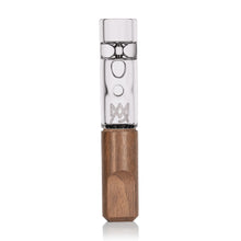 The MJ Arsenal Alpine Series Ridge Chillum Taster One Hitter features a transparent borosilicate glass mouthpiece with etched designs and a hexagonal wooden base, displayed upright on a white background.