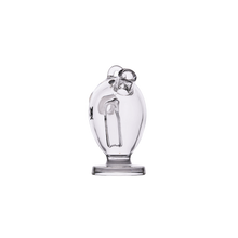 A clear glass sculpture with an abstract heart shape on a round base echoes the sleek elegance of the MJ Arsenal Martian Original Blunt Bubbler, known for its smooth water filtration design.