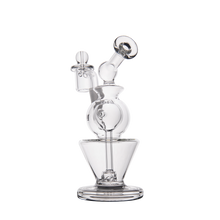 The MJ Arsenal Gemini Mini Dab Rig features clear borosilicate glass, a round chamber, angled mouthpiece, flat base, and small glass handle. Compact and portable, it's perfect for easy sessions. Displayed on a white background.
