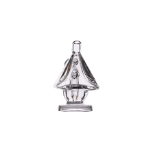 The MJ Arsenal King Bubbler, crafted from clear borosilicate glass and shaped like a sailboat with a sail and base, is shown against a plain white background.