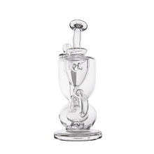 The MJ Arsenal Titan Mini Dab Rig is a clear borosilicate glass piece with a unique, artistic shape, central chamber, angled mouthpiece, and sturdy base, shown on a plain white background.