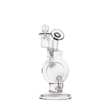 The MJ Arsenal Atlas Mini Dab Rig is a clear borosilicate glass water pipe featuring a round central chamber, angled mouthpiece, sturdy base, and unique vertical and horizontal elements, shown on a plain white background.