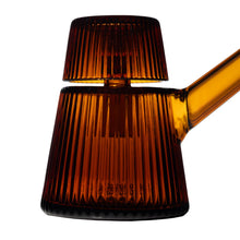 A close-up of the NWTN Home Deco Bubbler, a modern ribbed amber borosilicate glass container with a matching lid and angled handle, set against a white background.