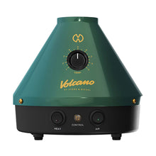 The Storz & Bickel Volcano Classic is a green and black, cone-shaped German vaporizer with convection heating, a temperature dial, and Heat, Control, and Air buttons. "Volcano by Storz & Bickel" is printed in gold on the front.